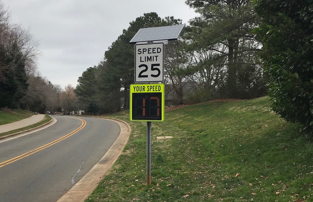 Radar sign under speed limit sign