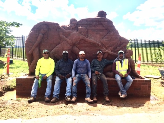 Workers in front of brick relief sculpture