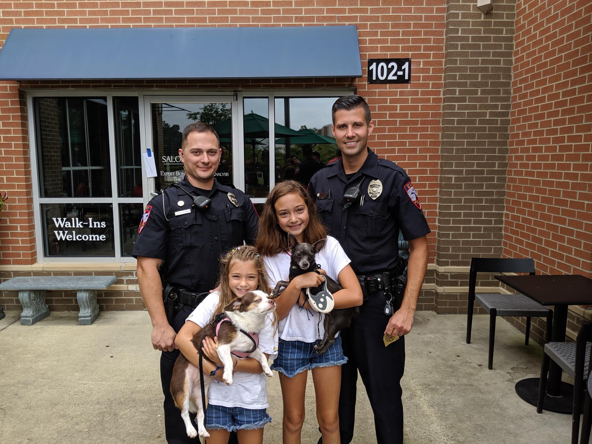 Police officers with two children holding puppies