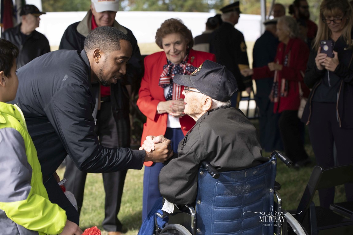 Man shaking hands with veteran at Veterans Day Observance