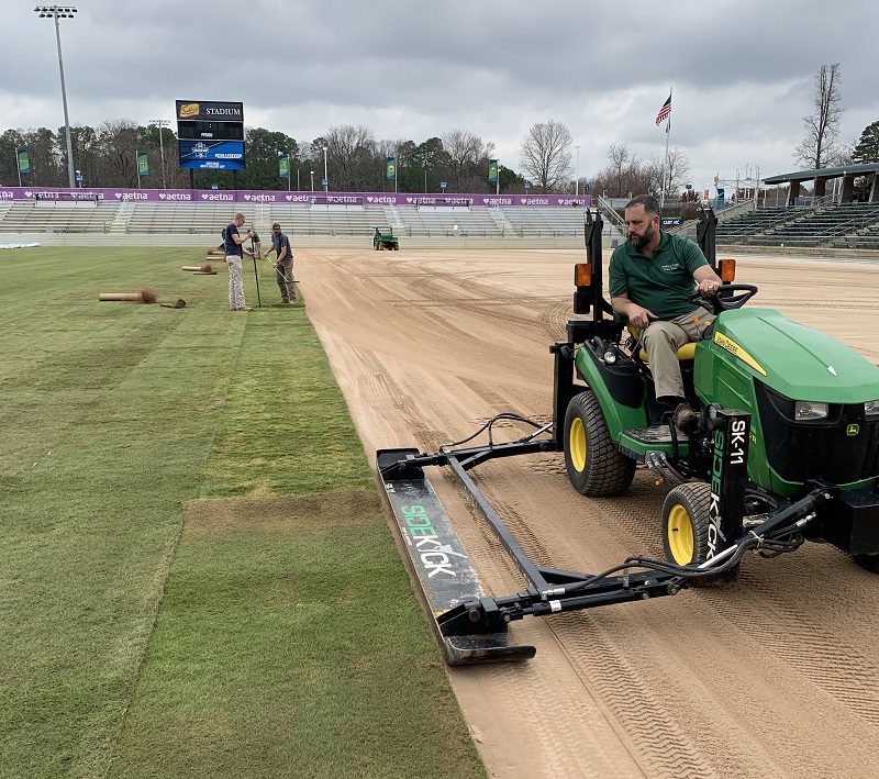 Worker tending to sod at WakeMed Stadium