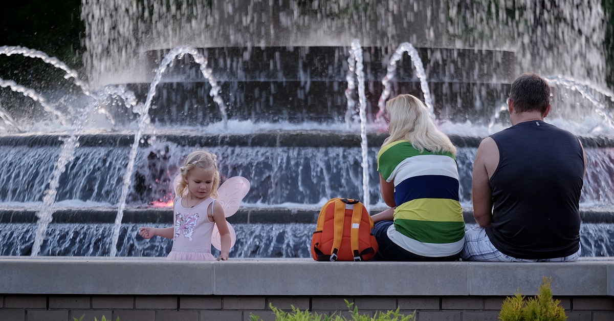 Family sitting at Downtown Park Fountain