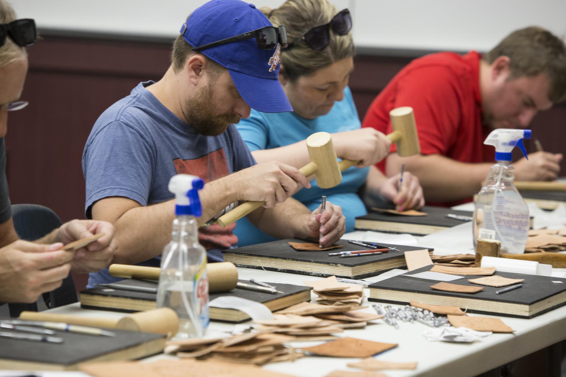 Participants engaged in a leatherworking activity