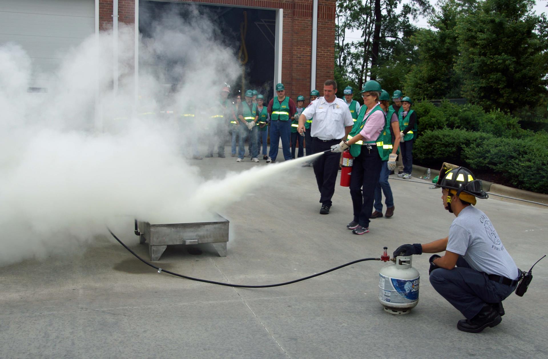 CERT participants putting out a fire with a fire extinguisher