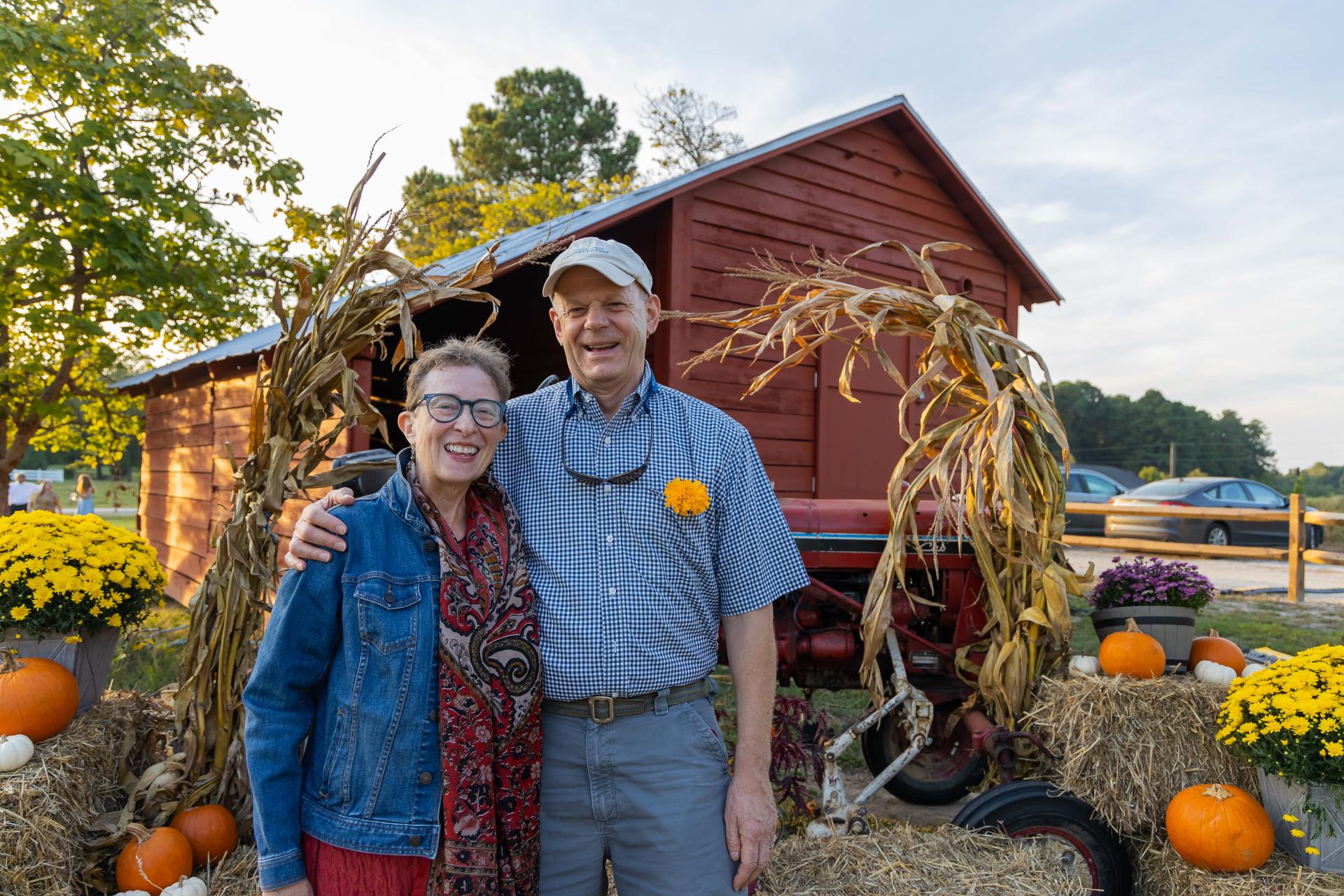 man and woman in front of barn