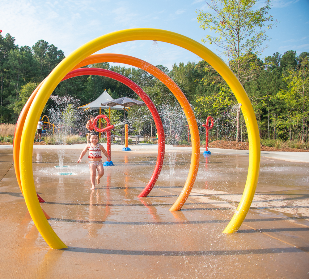 Girl running through sprayground feature