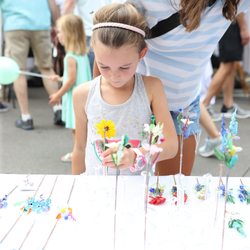 child looking at glass flower