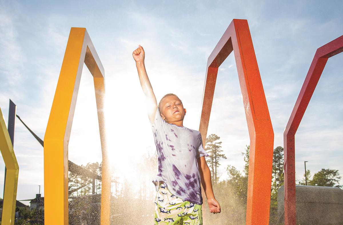 Child playing at misting sculpture 