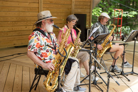 3 people playing saxophones on stage