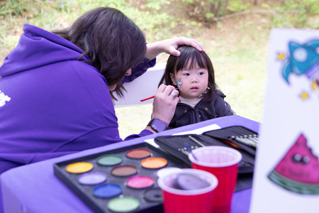 Person painting the face of a child