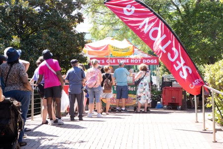 A line of people at a hot dog cart at Lazy Daze 2024