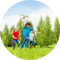 kids running field airplane trees