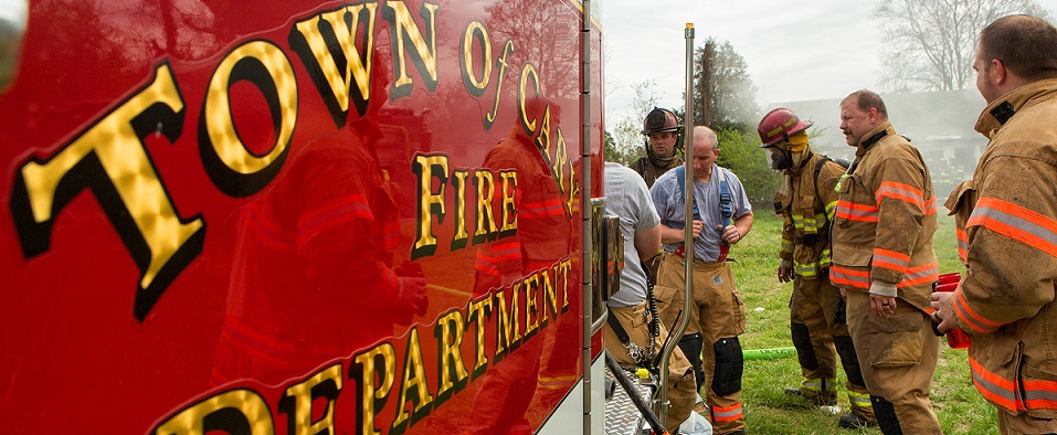 Firefighters next to a fire truck